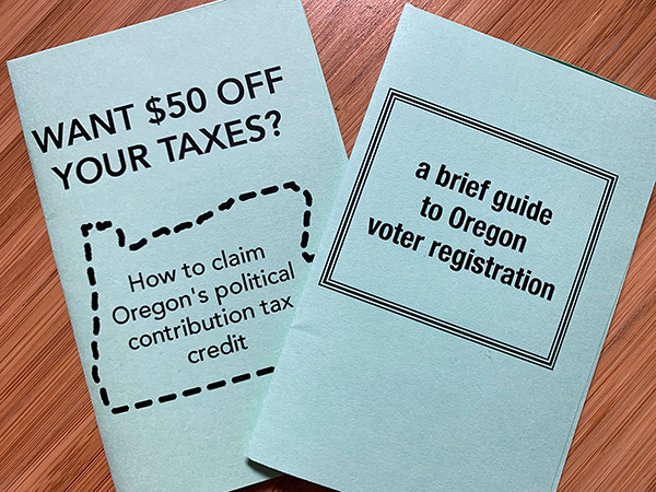 Two mini-zines printed on green paper and on a wood grain background. The first zine is titled "Want $50 Off Your Taxes? How to claim Oregon's political contribution tax credit." The second zine is titled "a brief guide to Oregon voter registration."